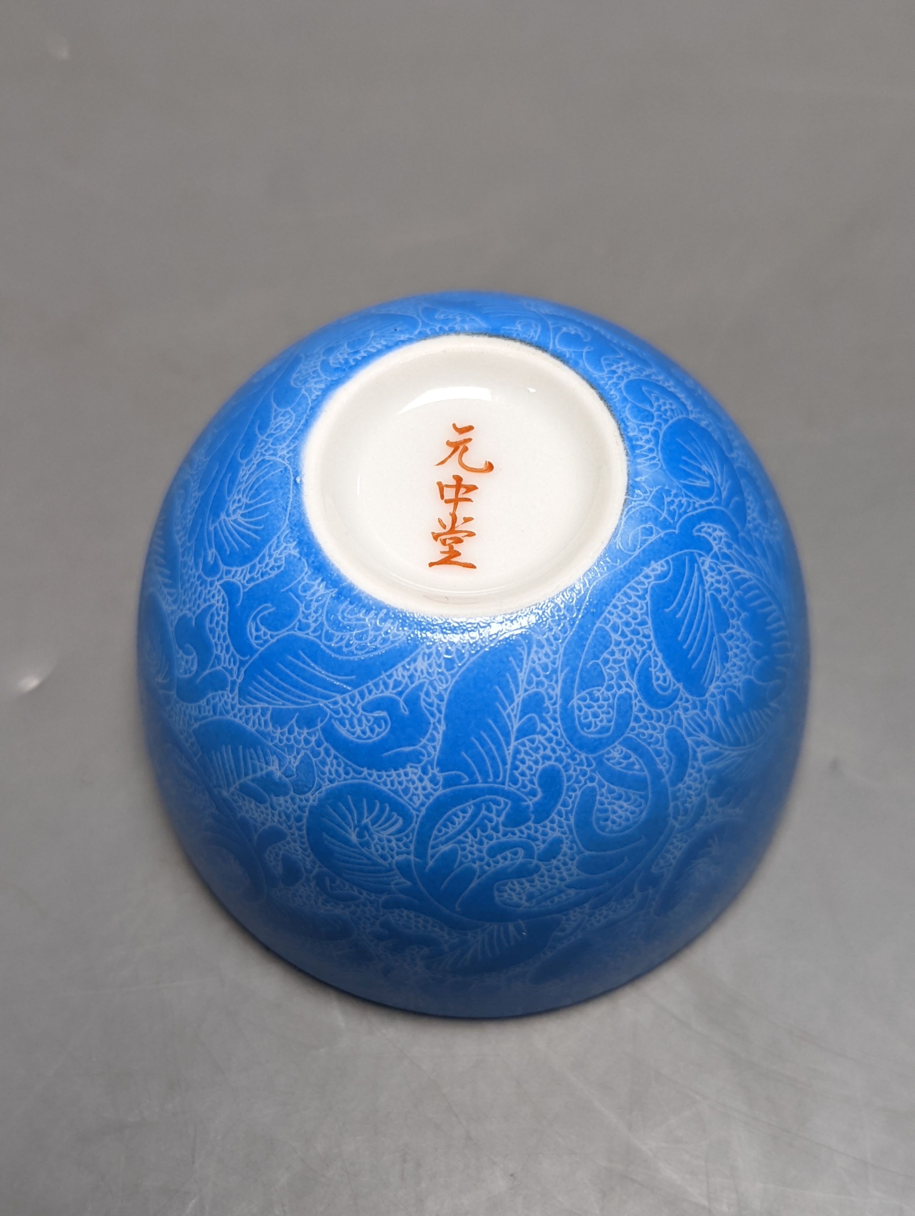 A Japanese or Chinese sgrafitto blue enamelled cup, cased. 6cm diameter